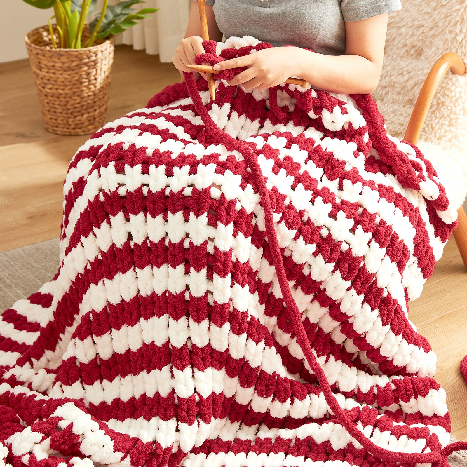 Close up of handmade chunky chenille yarn in Red Stripe being knitted showing thick soft loops #color_Red Stripe