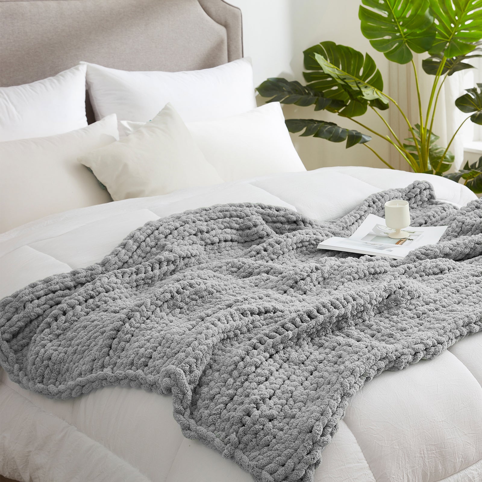 Chunky knit throw blanket in Light Grey layered on a bed in a modern bedroom setting #color_Light Grey