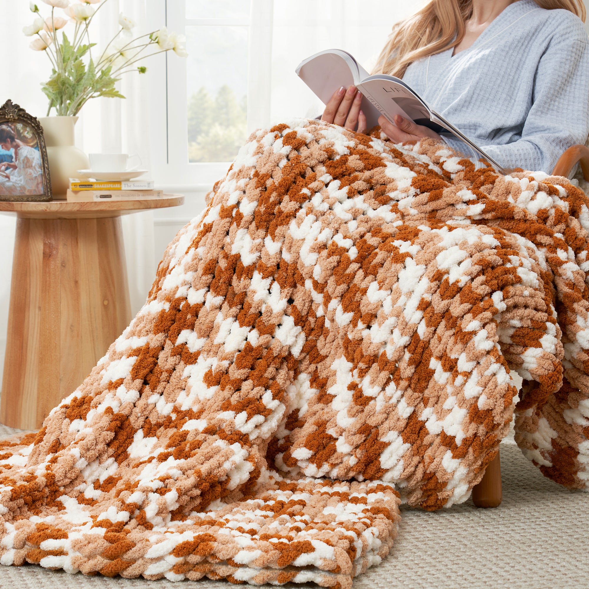 Woman relaxing with a handmade chunky chenille knit throw blanket in Burnt Orange while reading  #color_Burnt Orange