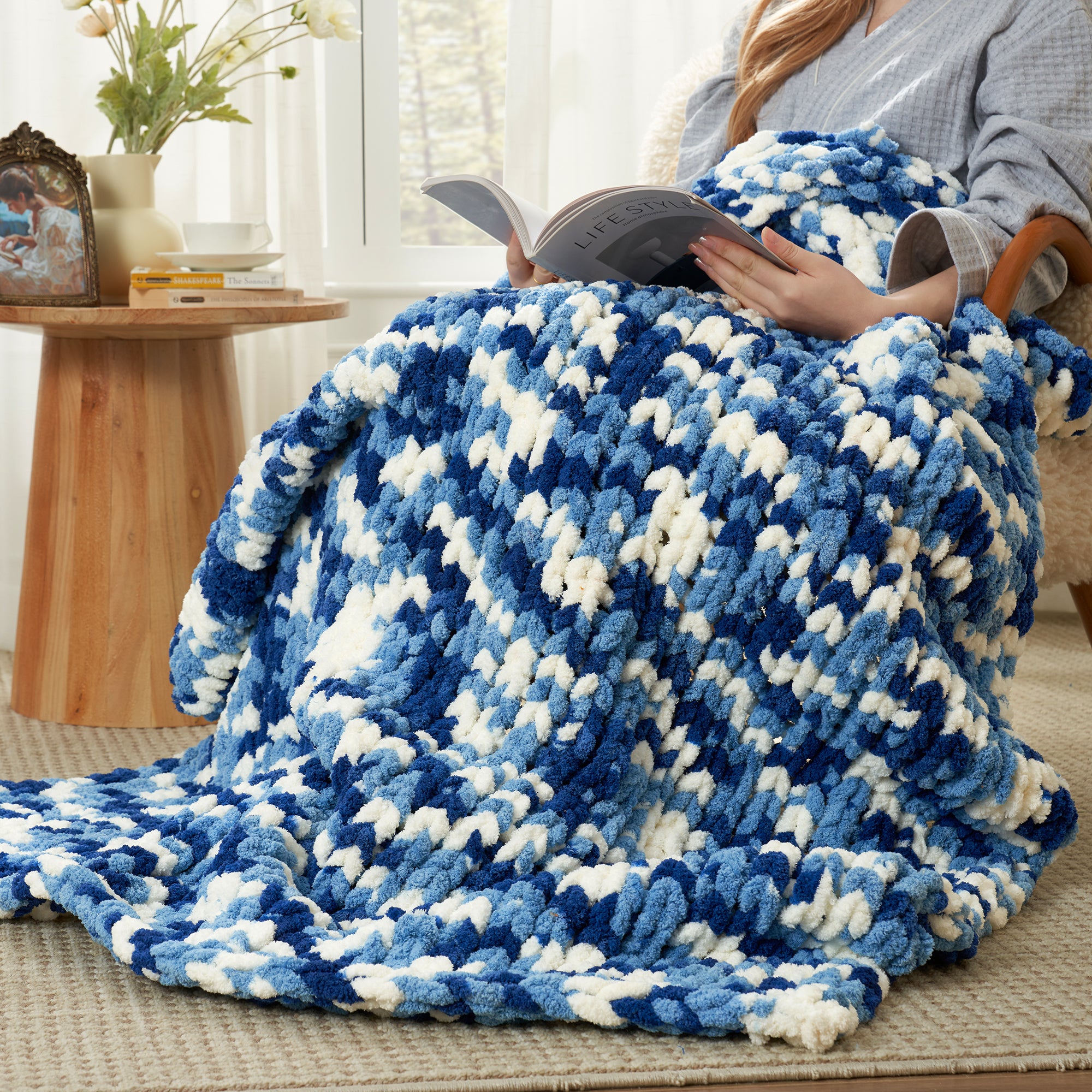 Woman relaxing with a handmade chunky chenille knit throw blanket in Blue while reading #color_Blue