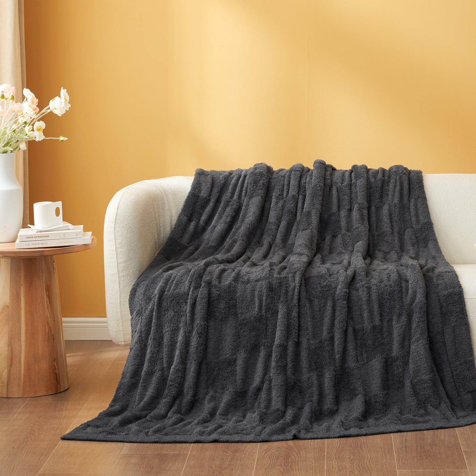UltraCozy Solid Checkered Feather Yarn Knit Throw Blanket on a beige couch - #Color_Solid Dark Grey