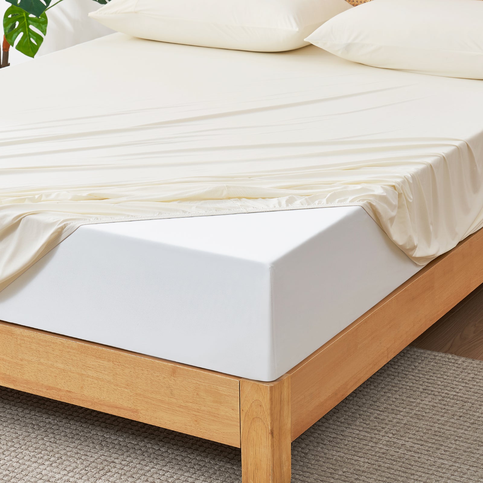 White Snuggle Sac fitted sheet set on wooden bed.#color_White