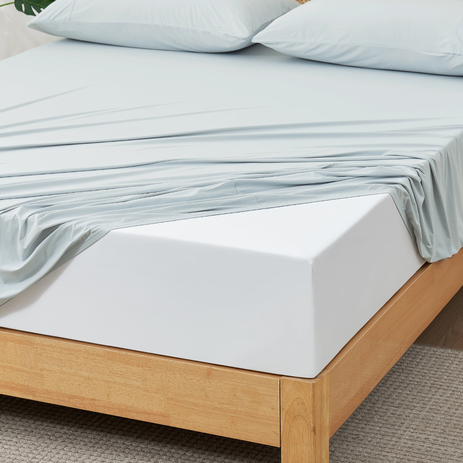Blue Snuggle Sac fitted sheet set on wooden bed.#color_Blue