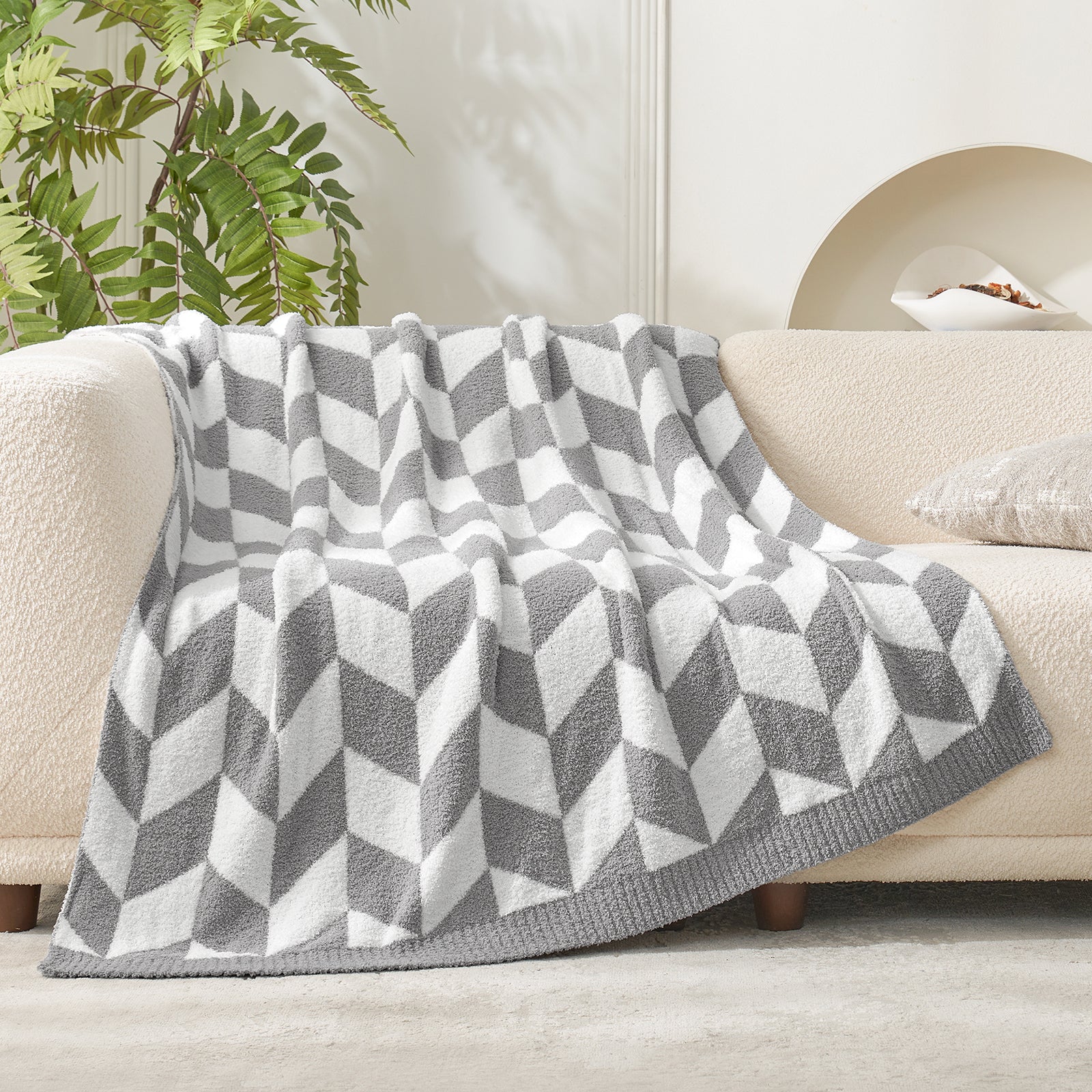 Snuggle Sacs Chevron Feather Yarn Knit Throw Blanket on the couch with plant #color_Grey