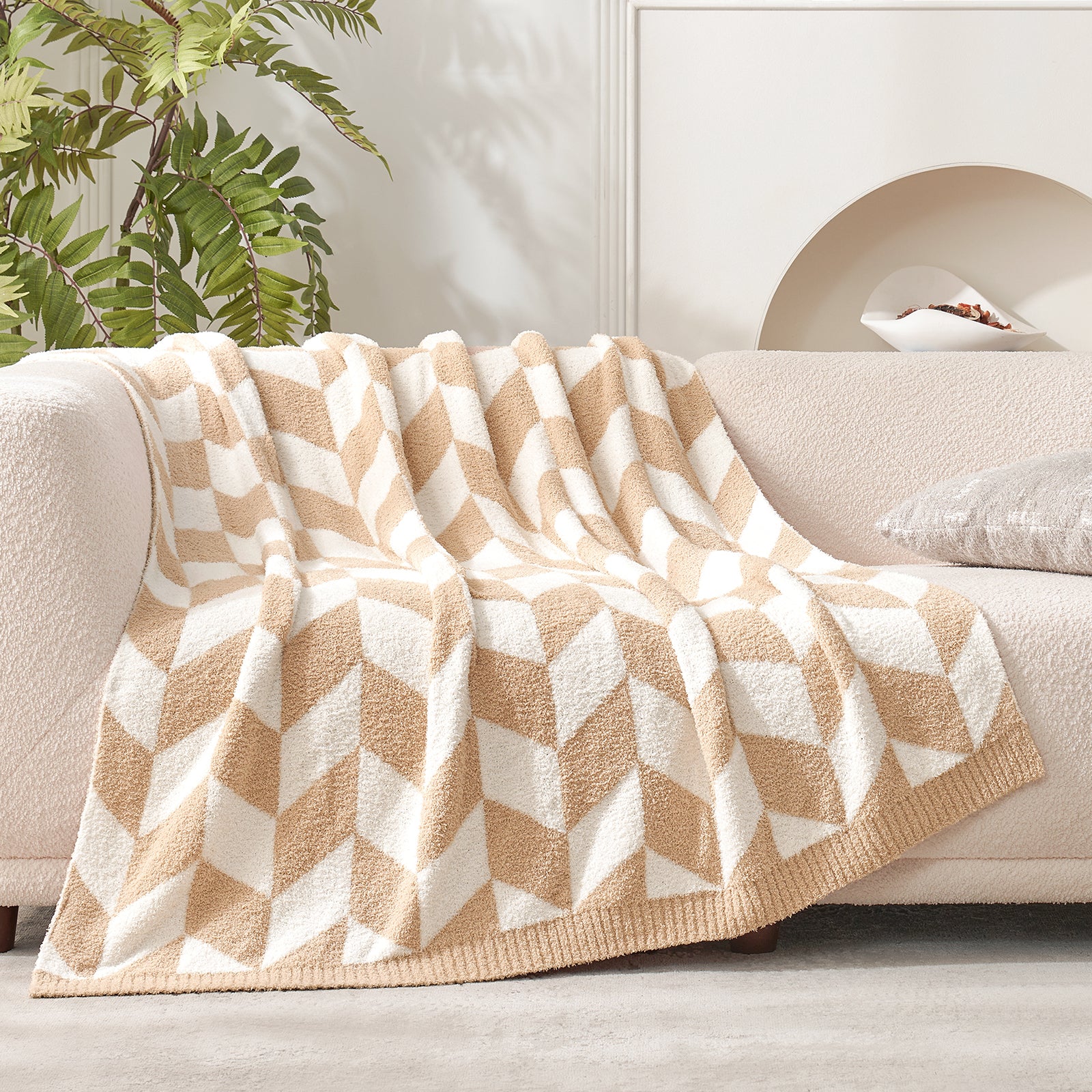 Snuggle Sacs Chevron Feather Yarn Knit Throw Blanket on the couch near the plant #color_Beige