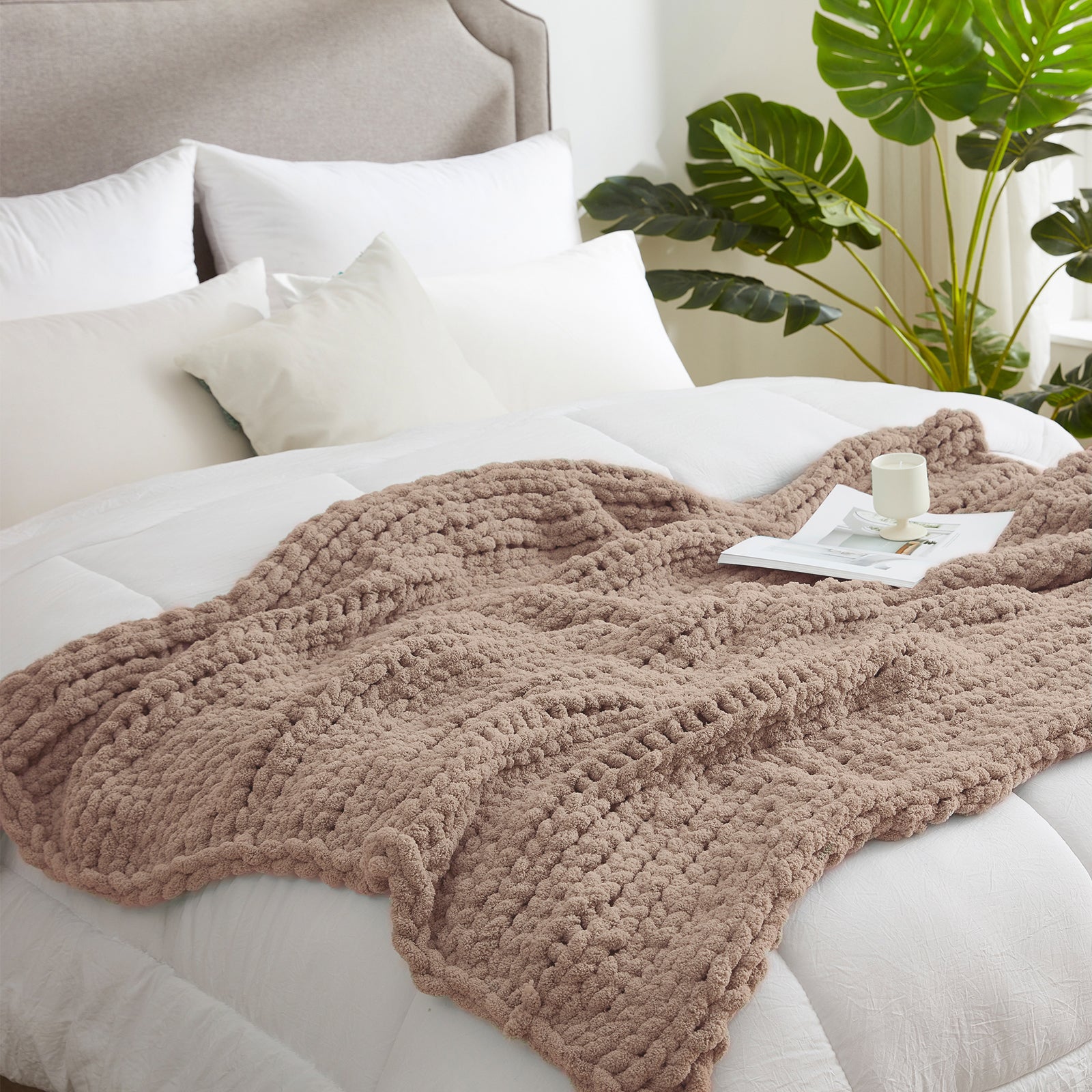 Soft chunky knit throw blanket in Beige layered on bed in a modern bedroom setting #color_Beige