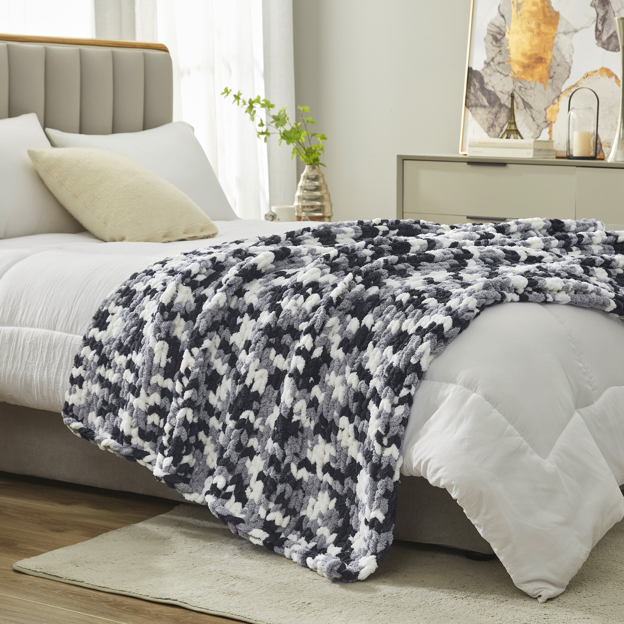 Chunky chenille knit throw blanket in Black placed at the end of a bed adding texture and warmth #color_Black