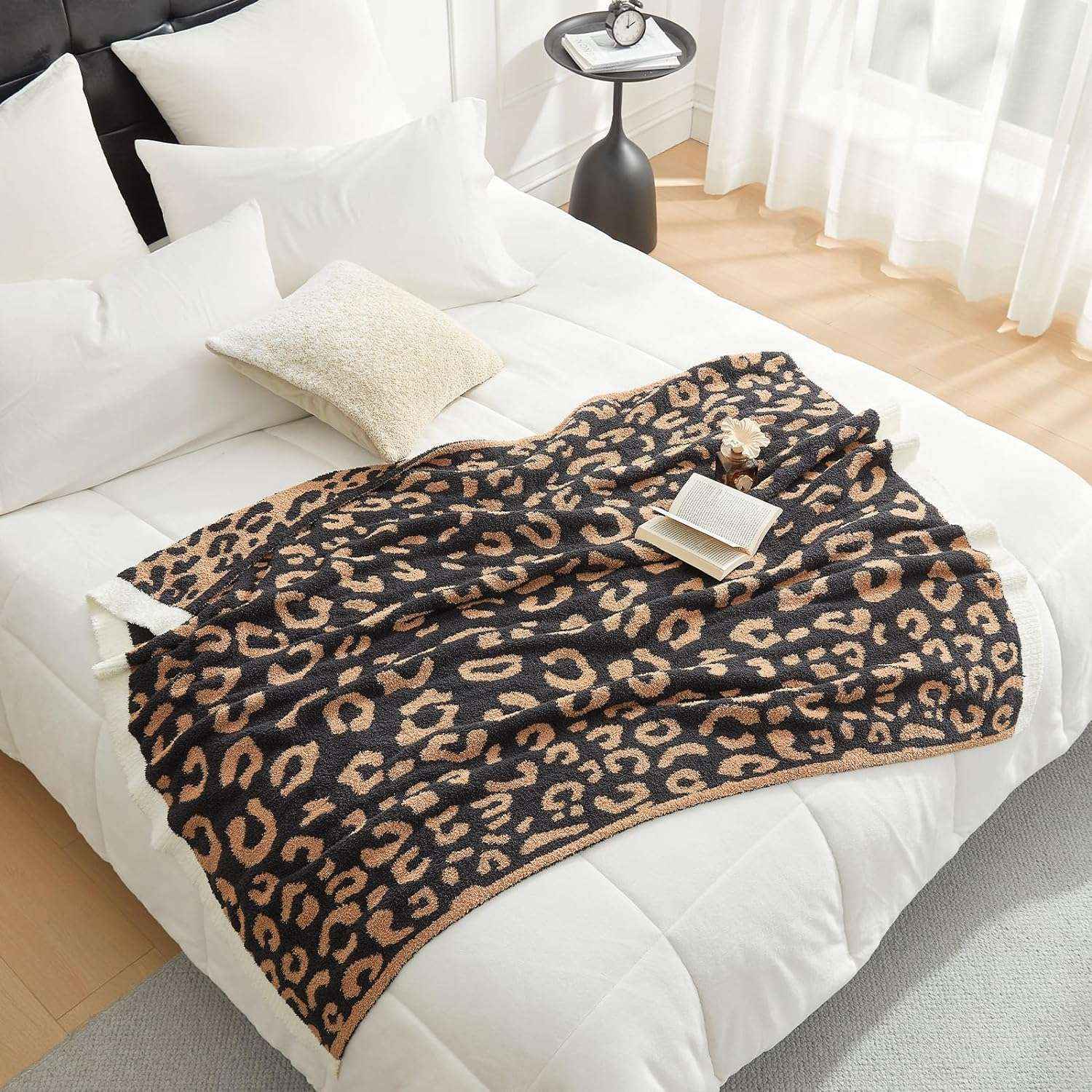 Reversible Leopard Feather Yarn Knit Throw Blanket on a bed with a magazine in a bright room#Color_Black
