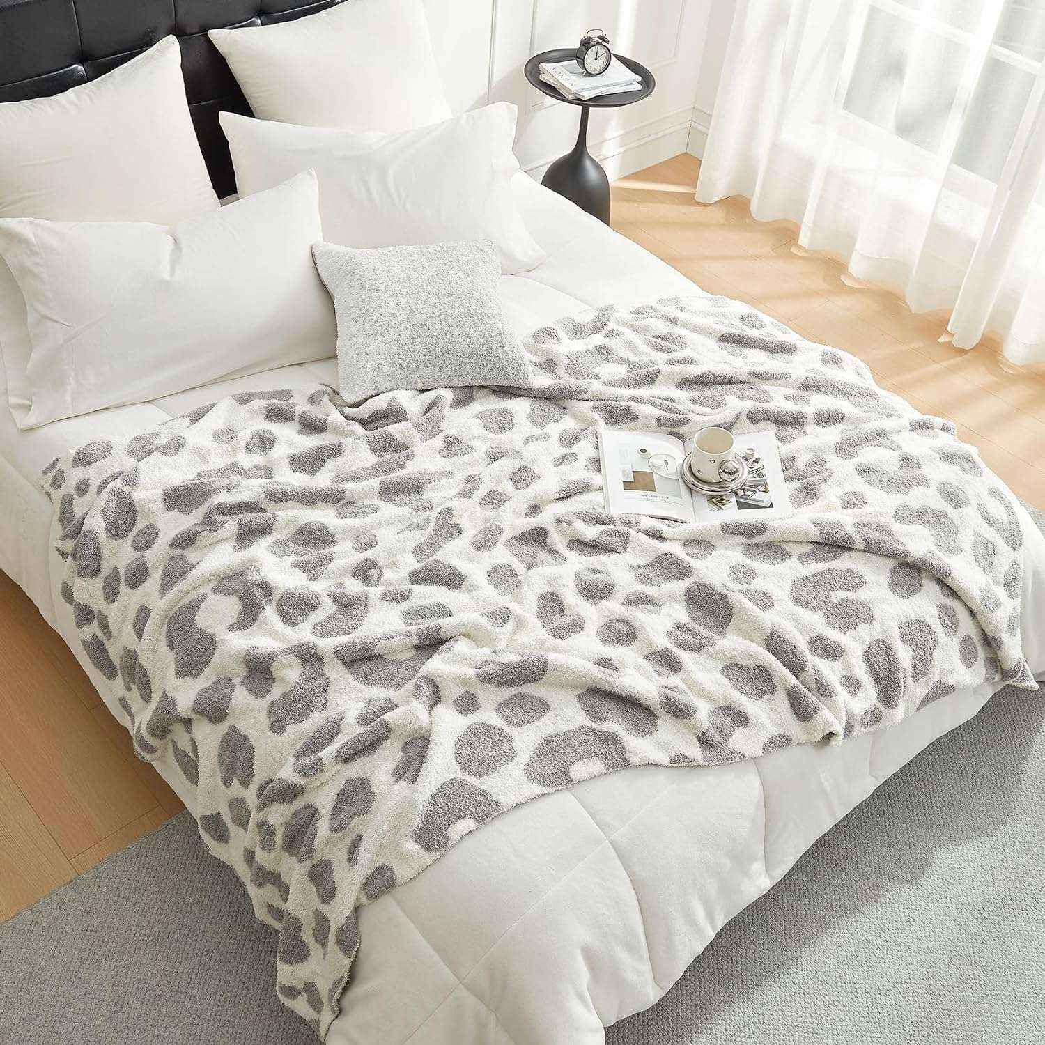 Reversible Leopard Feather Yarn Knit Throw Blanket on a bed with a mug and magazine in a bright room#Color_Leopard Grey