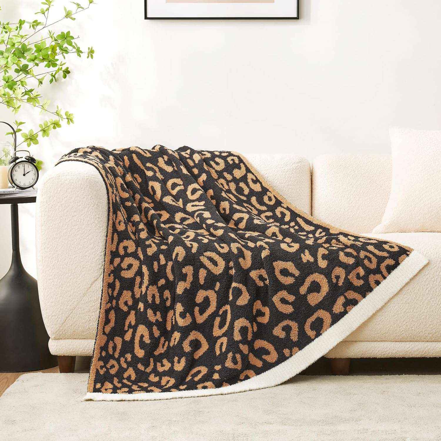 Reversible Leopard Feather Yarn Knit Throw Blanket on a beige couch in a bright room #Color_Black