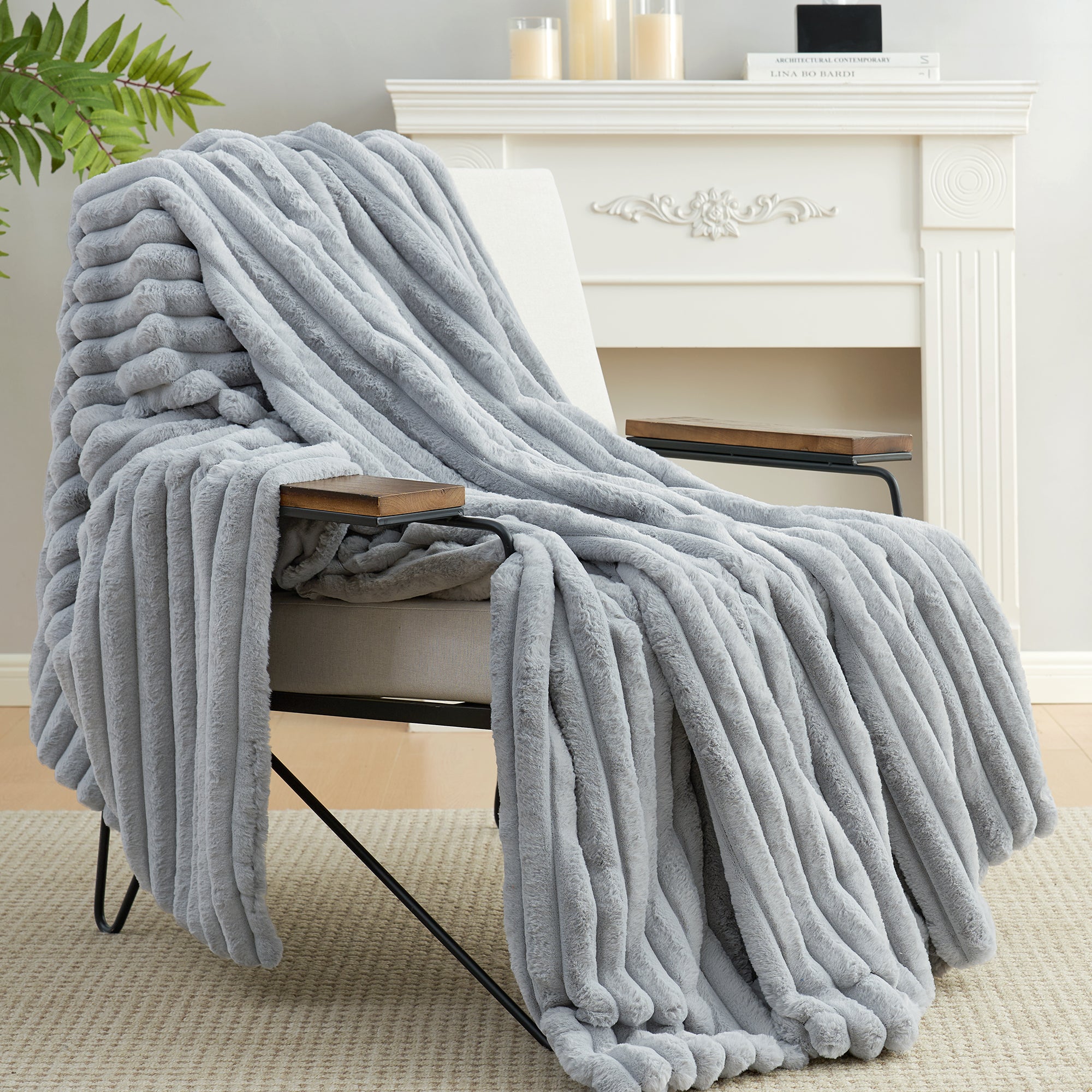 Snuggle Sac striped faux fur throw blanket in Light Grey draped over a chair near a fireplace, creating a warm and inviting atmosphere #color_Light Grey