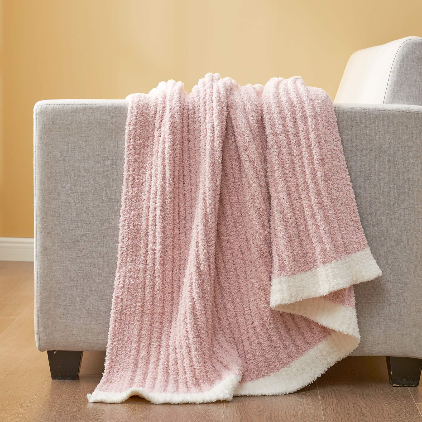 Snuggle Sac UltraSoft Ribbed Feather Yarn Knit Throw Blanket draped on the sofa#Color_Pink