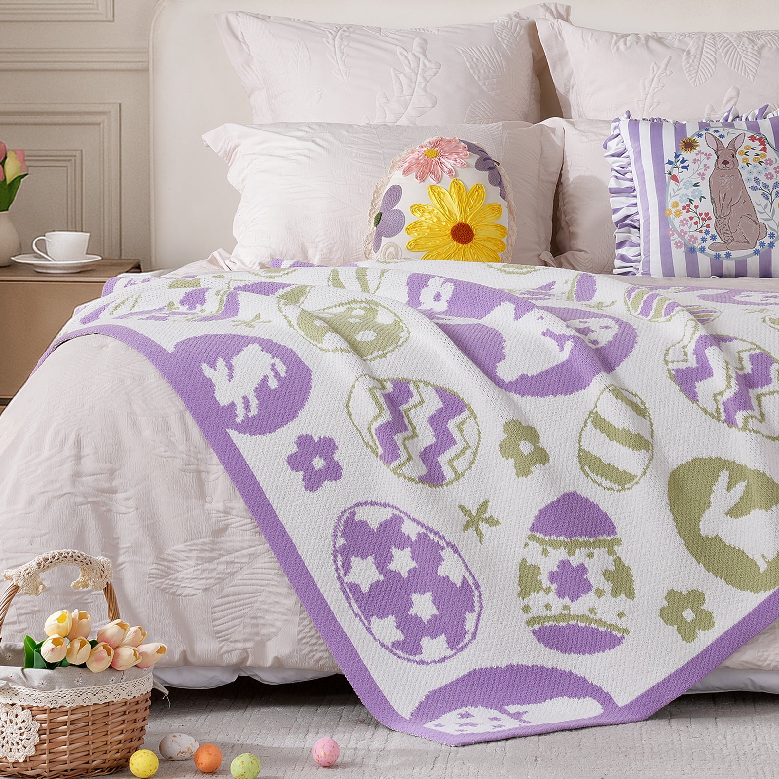 Chenille knit throw blanket in purple with bunny and egg design placed at the foot of a bed #color_Purple