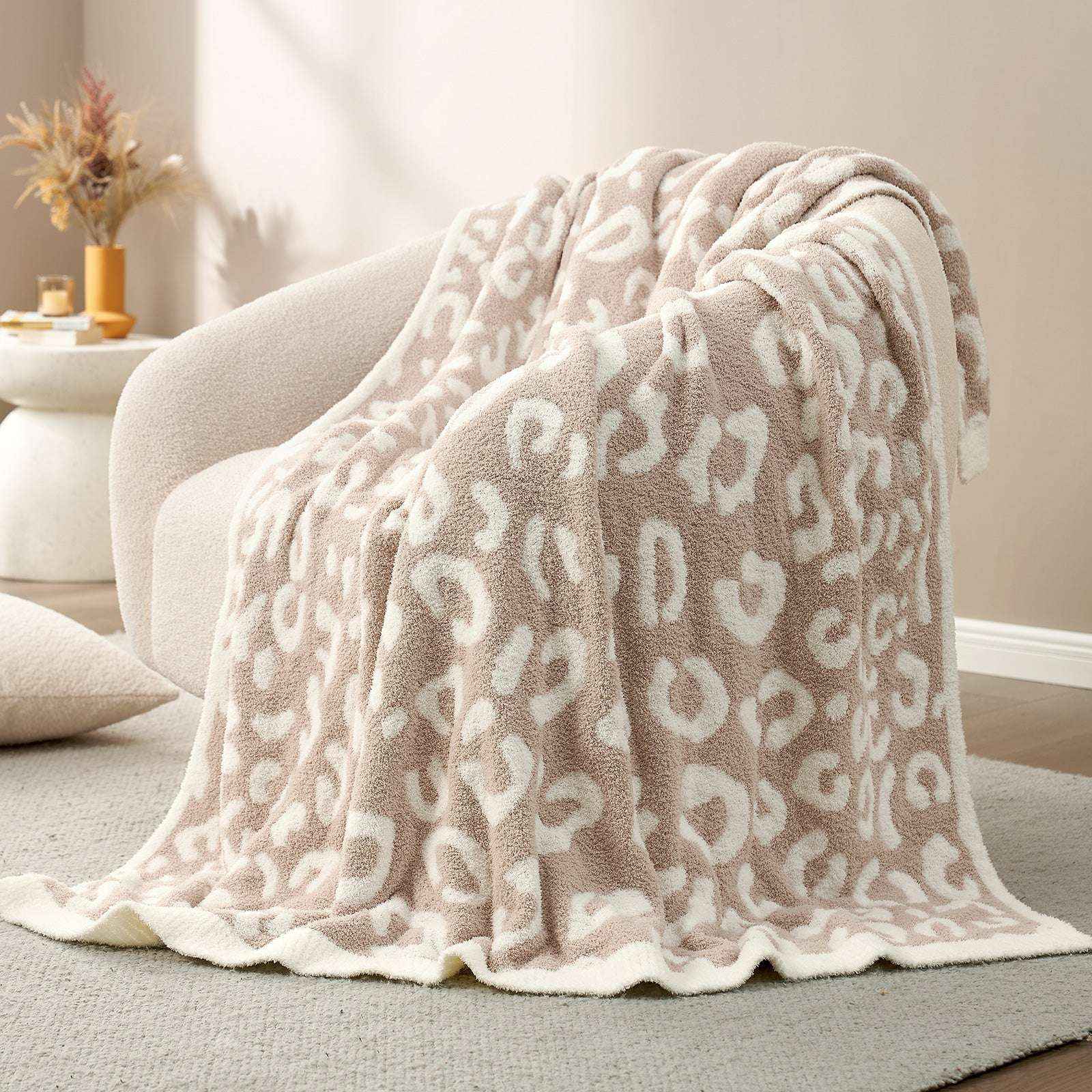 Reversible Leopard Feather Yarn Knit Throw Blanket on a beige couch in a bright room #Color_Leopard Beige