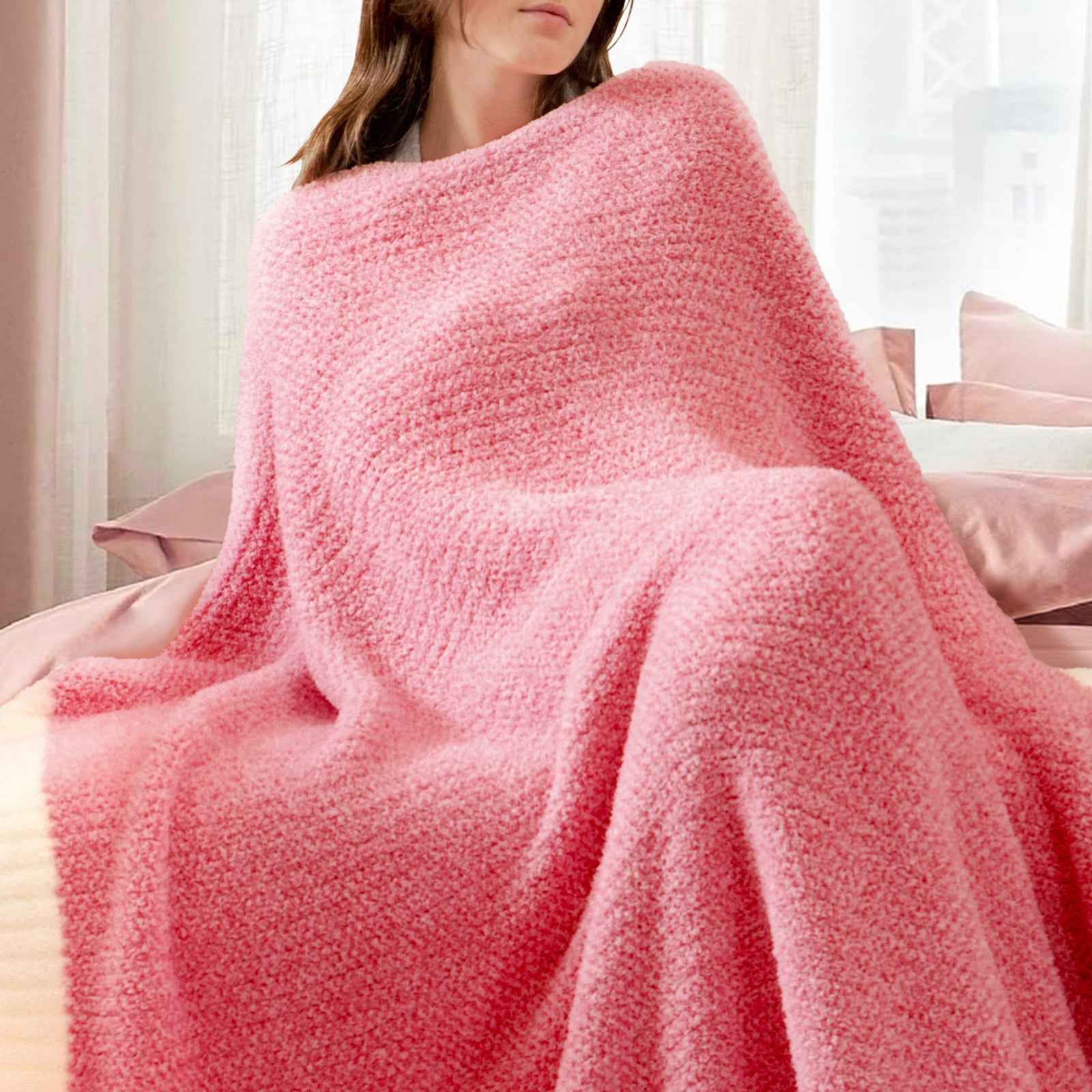 A woman wrapped in Snuggle Sac Heather Feather Yarn Hot Pink Knit Throw Blanket #Color_Hot Pink