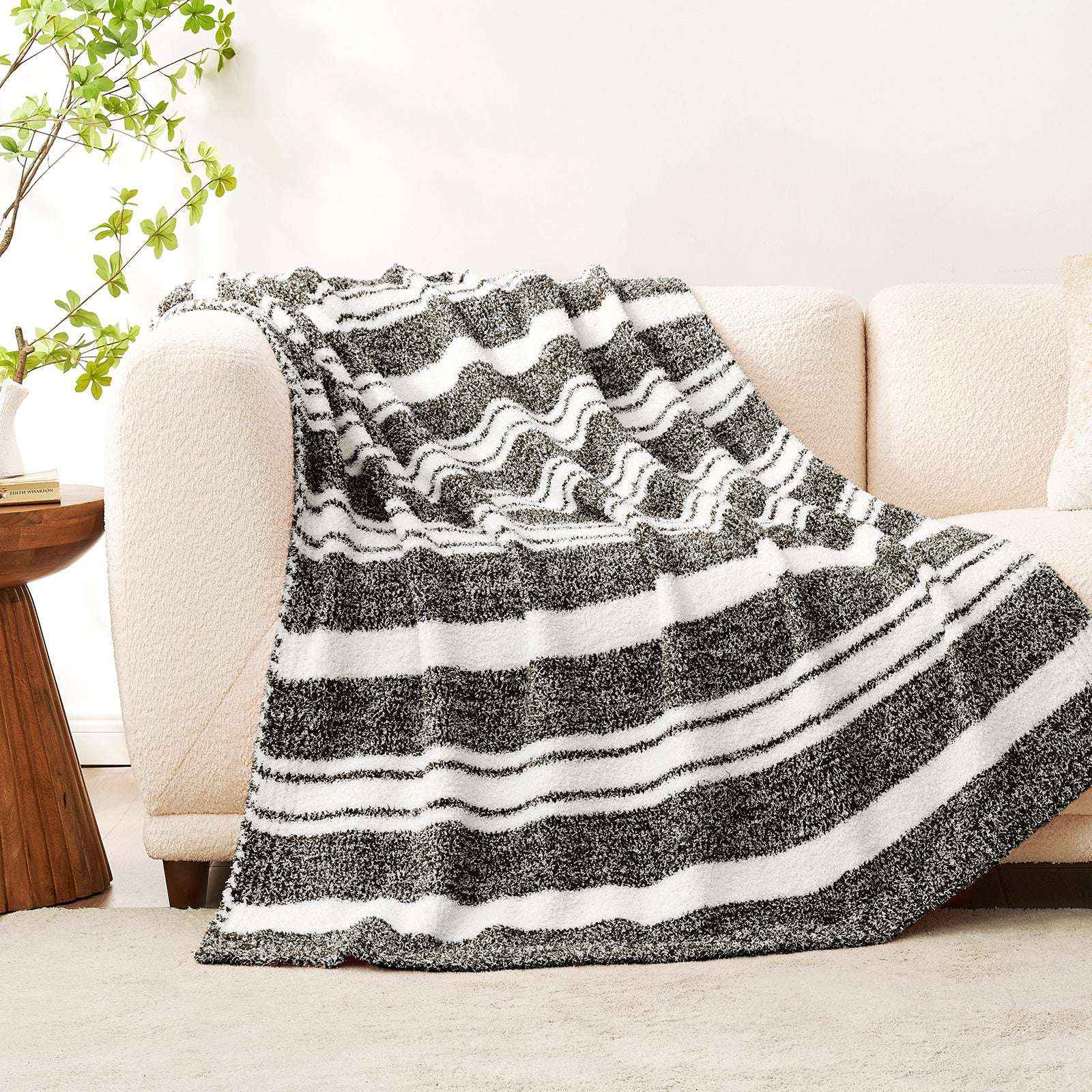 Striped Feather Yarn Knit Throw Blanket on a beige couch#Color_Black