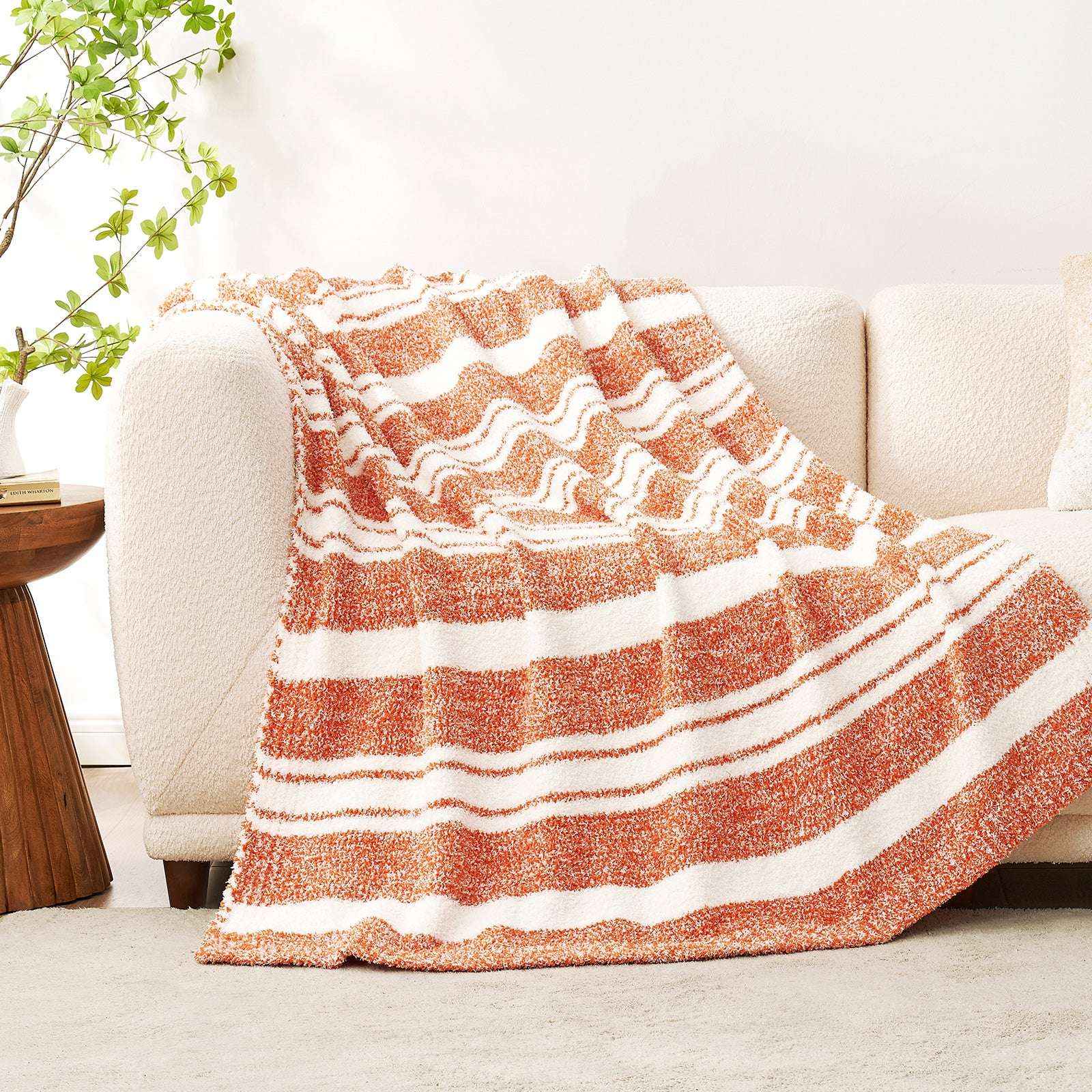 Striped Feather Yarn Knit Throw Blanket on a beige couch #Color_Orange